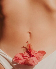 Close-up cropped naked belly girl with flower slender female body Concept beauty body skin care health cosmetics spa