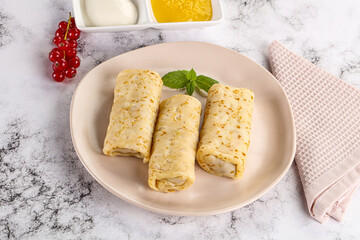Homemade stuffed pancakes with honey and cream sour
