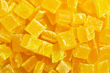 Diced mango dried fruits texture background, top view. Dehydrated mango chips dices, sweet food...