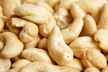 Cashew nut heap food texture background, macro shot. Yellow cashew kernels