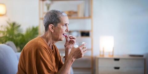 Close up Caucasian senior holding pill in hand with water feeling sick. from headache, painkiller, healthcare, medicine, treatment, therapy, patient, disease illness concept