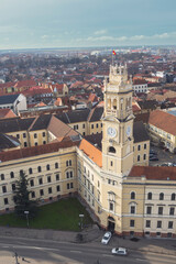 Naklejka na ściany i meble Aerial art nouveau historical a majestic art nouveau building with a prominent clock tower captured from an aerial perspective incity Oradea, Bihor, Romania