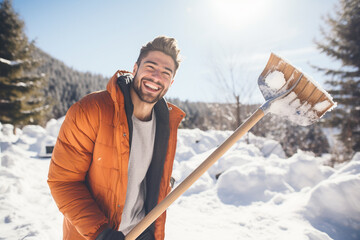 happy smiling handsome man clearing snow by shovel after snowfall , love winter - obrazy, fototapety, plakaty