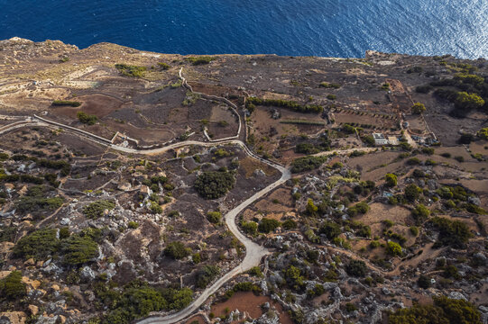 Aerial view of a road along the cliff facing the Ocean in Dingli, Malta.