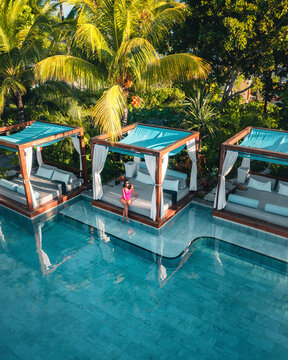 Aerial view of a woman relaxing along the swimming pool in a luxury resort, Poste de Flacq, Flacq district, Mauritius.