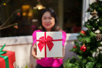 Happy excited asian woman hands holding Christmas gift box. cheerful girl packing Xmas present or open box xmas new year birthday gift.