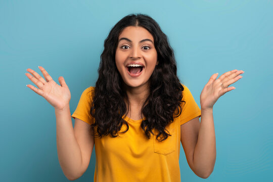 Amazed young indian woman gesturing on blue background - Powered by Adobe