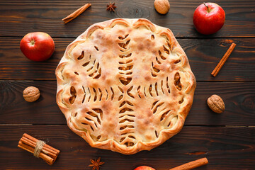 Apple pie top view. Bakery food, fresh red apples, spices, on dark brown rustic wooden table....