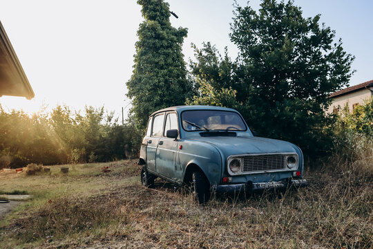 Codevilla, Italy - August 19, 2023: Old blue Renault 4 car left in a field in Italy, Lombardy