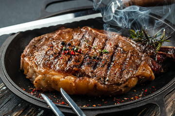 grilled marbled beef steak striploin with spices in a grill pan. place for text, top view