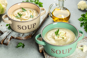 Homemade white cauliflower cream soup on a light background top view. place for text