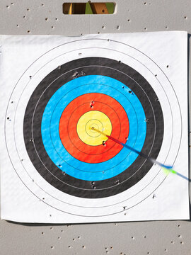 Archery target with arrow in bullseye