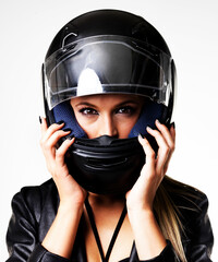 Closeup, face and woman with motorbike helmet on a studio background with fashion or clothing. White backdrop, front and serious female rider with protection and safety accessory or gear for style