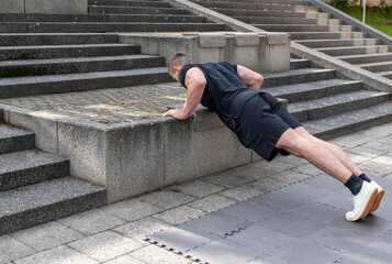 Incline push-up doing by a young athletic man. Push-up modification for beginners - obrazy, fototapety, plakaty