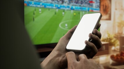 CU Black African-American male watching soccer at home, making bets on his phone