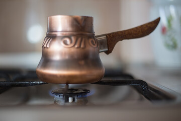 coffee is brewed on the stove in a copper Turk at home