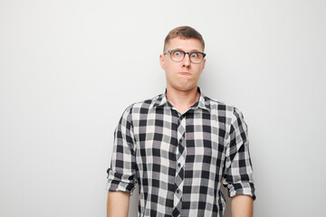 Portrait of young caucasian man puffing cheeks with funny face isolated on white studio background. Humor concept, mouth inflated with air crazy expression