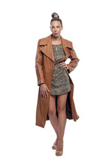 Beautiful stylish woman in a short dress, high-heeled shoes and a brown leather coat. Style, fashion and beauty. Full height. Isolirvoan on a white background. Vertical.