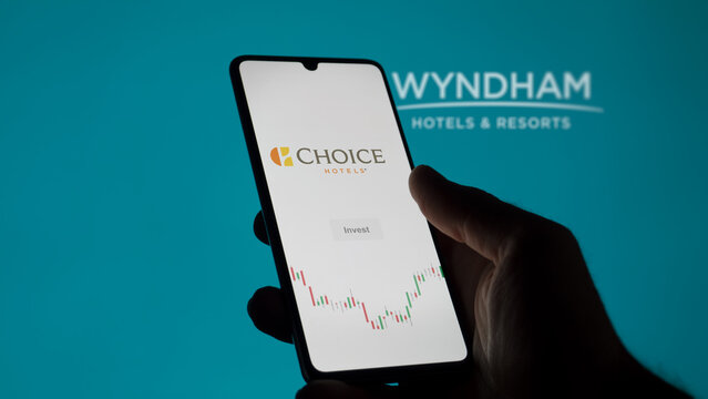 Choice Hotels page of a stock exchange on a phone, in the blurry background the logo of Wyndham