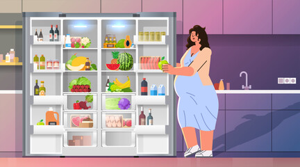 pregnant woman standing near refrigerator with fruits and vegetables nutrition diet during pregnancy motherhood expectation concept