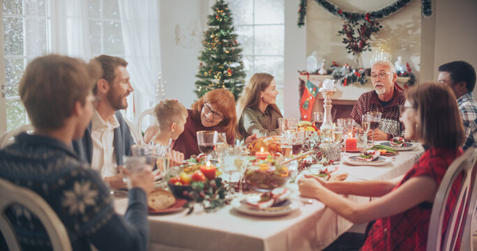 Multi-Generational Family Members Share Funny Stories and Joy During a Christmas Turkey Dinner. Home Is Filled with Holiday Spirit of the Winter Season as Relatives and Loved Ones Enjoy a Festive Meal