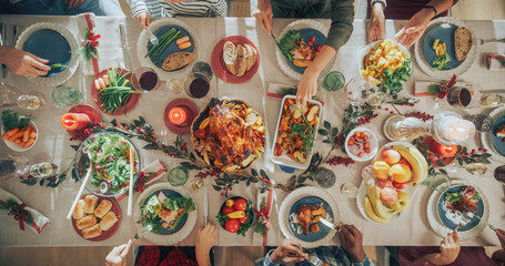 Diverse Group of Relatives and Friends Sitting Together Behind a Dining Table with Tasty Meals and...