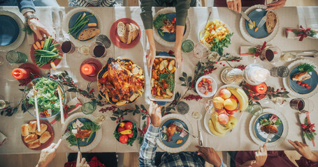 Top Down View with Anonymous Family, Children, Friends Gathered at Home for a Festive Christmas Dinner. Diverse People Enjoy Delicious Turkey Feast and Share Stories. Cozy Holiday Celebration