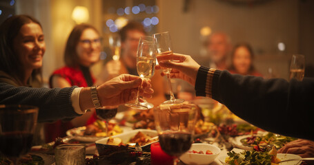 Family, Children and Friends Spend Christmas Dinner Together at Home in the Afternoon. Multicultural Family Raising and Clinking Champagne Glasses, Celebrating a Holiday with a Delicious Turkey Meal