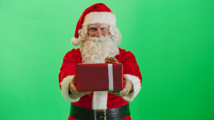 Studio Shot Isolated Mockup Template: Jolly Santa Claus Offering Gift In Red Wrapping Paper To Children On Green Screen Chromakey Background. Concept Of Christmas, Holidays, New Year