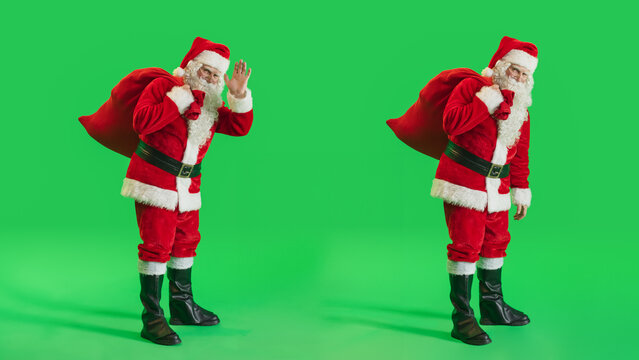 Studio Shot Isolated Mockup Template: Jolly Santa Claus with a Bag with Gifts For All Good Children On Green Screen Chromakey Background And Waving To Camera. Christmas And New Year - Powered by Adobe