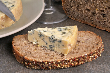 Morceau de fromage Fourme d'Ambert sur une tranche de pain aux graines en gros plan