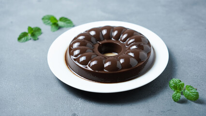 Chocolate Pudding on a white plate on a gray background.