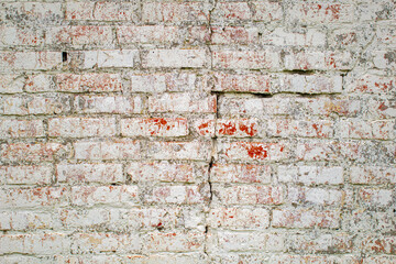 Textured rough surface of old shabby brick wall with peeling paint