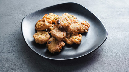 Fried tofu on a black plate. Single shot. Table Top.