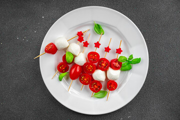 Caprese canapés mozzarella and tomato appetizer salad on a skewer finger food delicious healthy eating cooking appetizer meal food snack on the table copy space food background rustic top view 