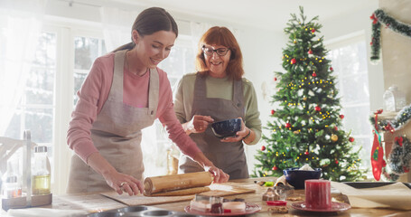 Portrait of Adult Woman Preparing Gingerbread for Christmas While her Senior Mother is Helping....
