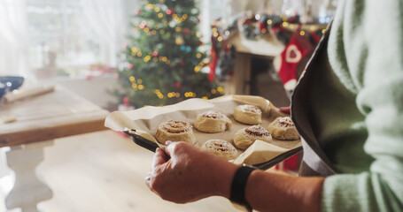Close Up of a Senior Female Preparing Making Cinnamon Buns for Christmas at Home. Cheerful...