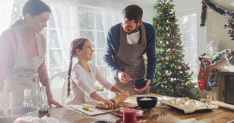 Happy Family During Christmas: Portrait of Little Cute Girl Learning How to Make Cookies and Celebrating her Achievement with her Parents. Cute Family Preparing Together for Holiday Dinner