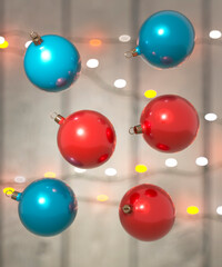 Shiny red and blue baubles close up with Christmas lights in the background 3d render