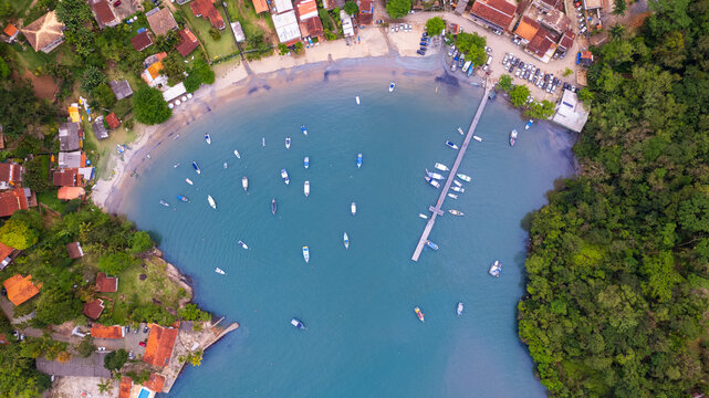 tropical beach with trees, blue water and boats