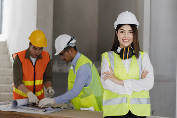 Asian engineers team working and design building project at construction in site office, Engineers meeting together to planning concept.