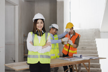 Asian engineers team working and design building project at construction in site office, Engineers meeting together to planning concept.