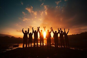Inspirational team moment Silhouettes celebrate by raising their hands together