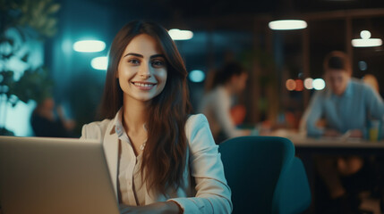 Fototapeta premium Beautiful young woman in casual clothing using laptop and smiling while working indoors. Generative AI