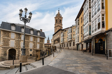 Alley with historic buildings and old church tower in the monumental city of Vitoria, Spain. - obrazy, fototapety, plakaty