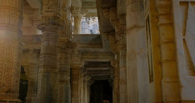 Sun and interior of beautiful Ranakpur Jain temple or Chaturmukha Dharana Vihara. Marble ancient medieval carved sculpture carvings of sacred place of jainism worship. Ranakpur, Rajasthan. India