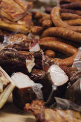 Hand made smoked meat products. Display meats, cold cuts and sausages at the street food fair. Soft focus blurred and noise effect. Delicatessen Concept