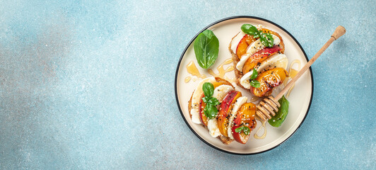 Italian Caprese salad with peaches, mozzarella on toast. Long banner format. top view