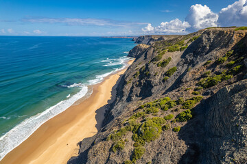 Sandy beach and dramatic cliffs on Atlantic Ocean coastline in Portugal