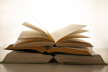 Open book and pages turned, backlit, on a white background. Passion for reading.
